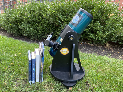 Telescope A telescope next to a few books placed on the grass outside of one of the library's branches.