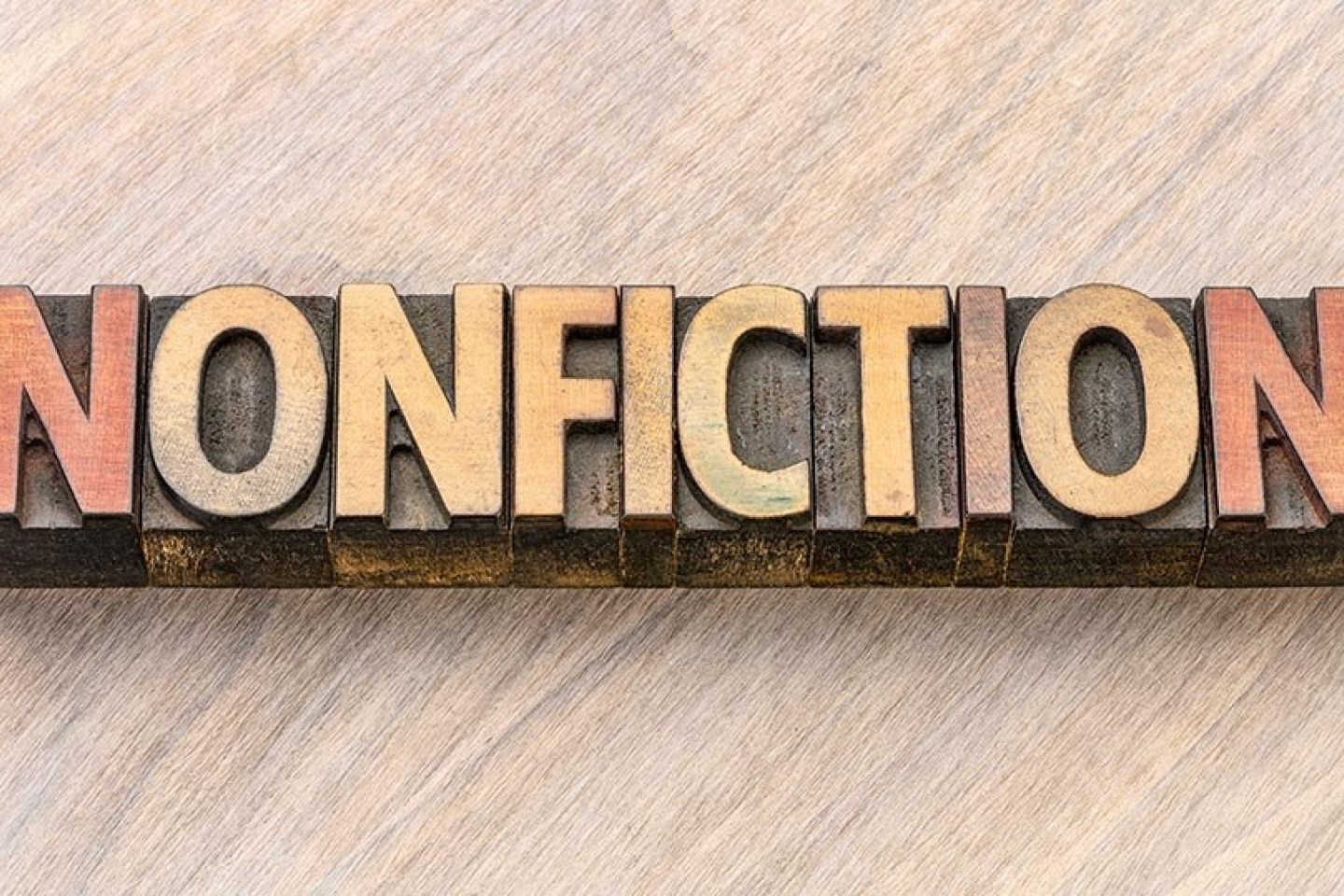 Woodblock printing pieces are lined together to spell "Nonfiction."