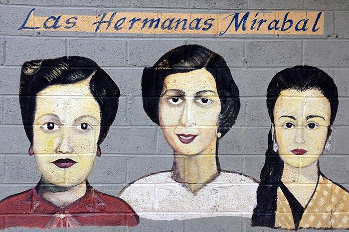 A mural of the Mirabal sisters on a gray brick wall. Above the cartoon portraits of the three women are the words "Las Hermanas Mirabal"