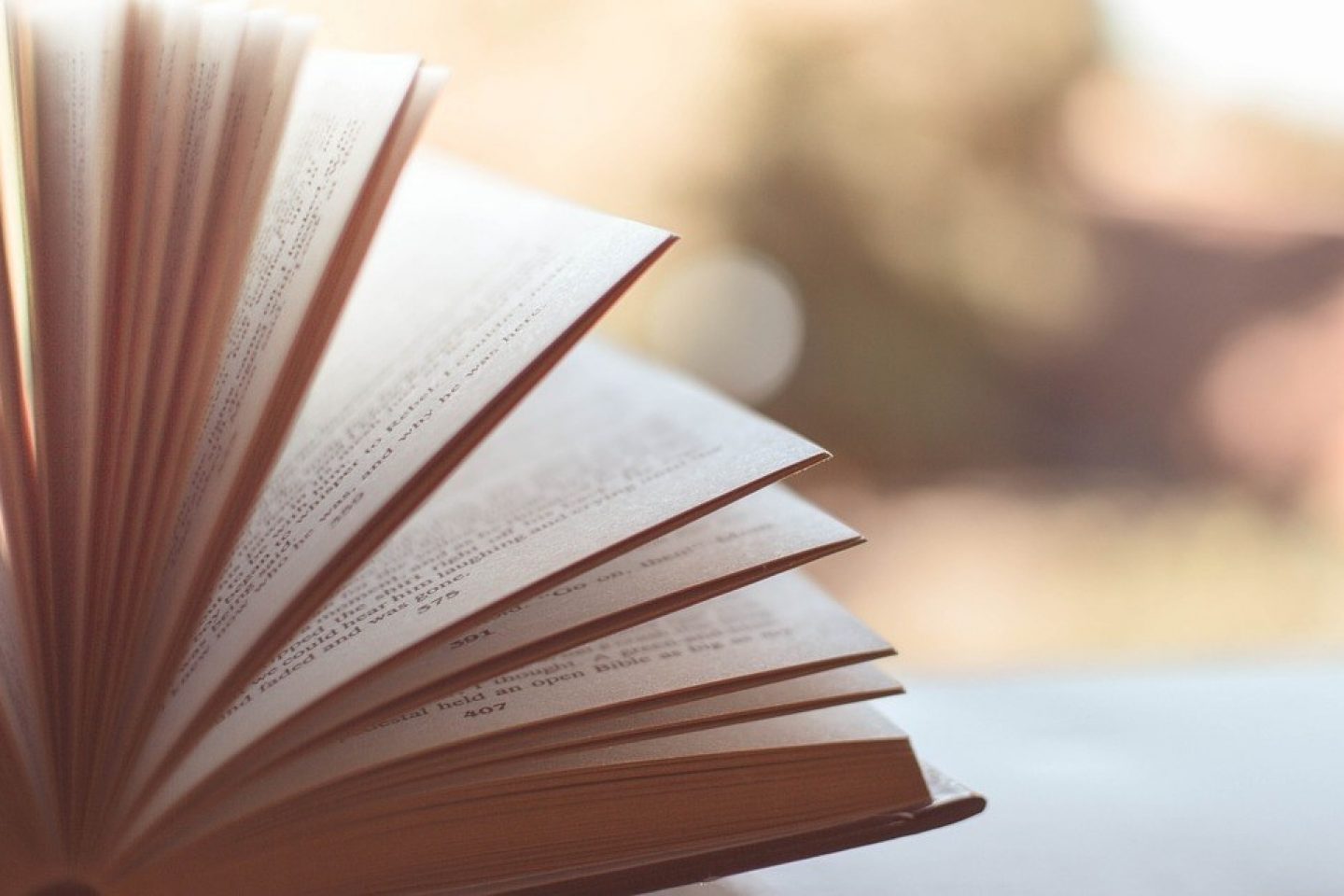 A close-up view of an open book with its pages being flipped through.