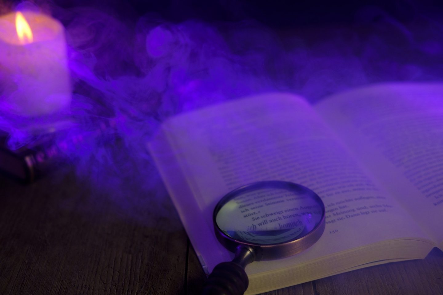 A spooky scene with purple fog, a lit candle, and a magnifying glass sit on top of an open book written in German.