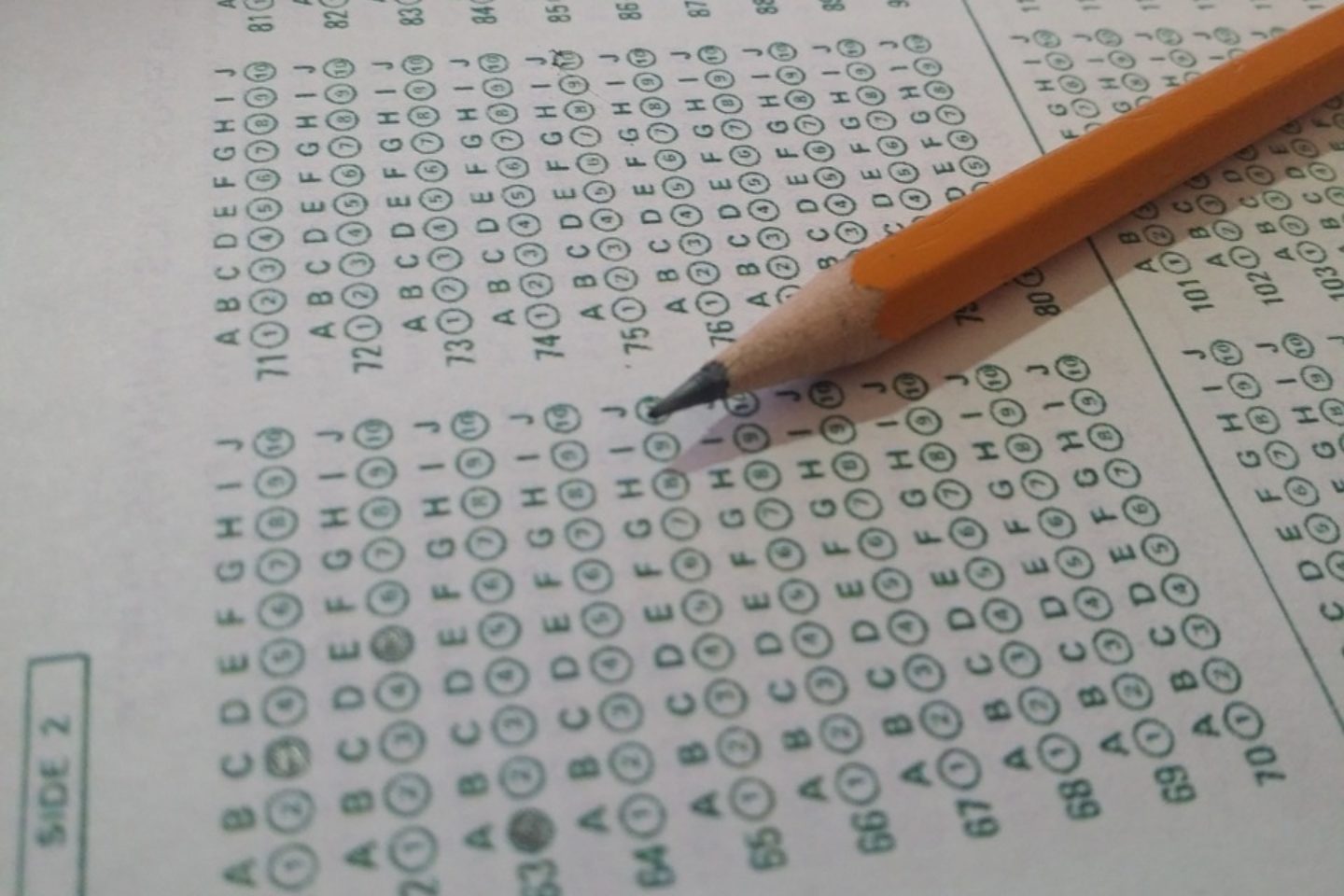 A close-up view of an unfilled ACT Test with a number two pencil sat on top of the paper.