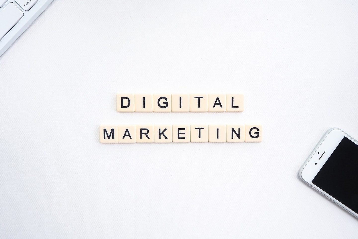 Scrabble board pieces come together to create two lines of text that spell out "Digital Marketing."