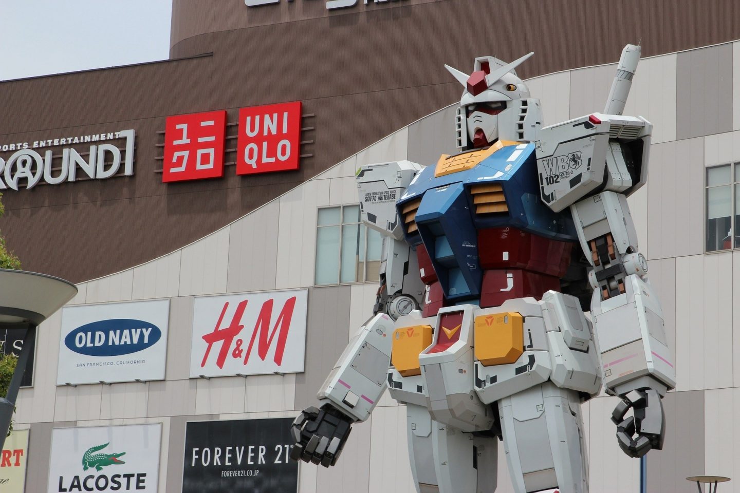 Gundam statue from Japan outside of a building advertising local stores.