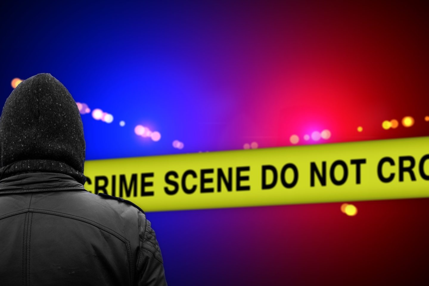 A photoshopped image of a man in a black hood and jacket facing away from the viewer. He is walking towards a "Do Not Cross Crime Scene" banner where red and blue lights flash behind it.