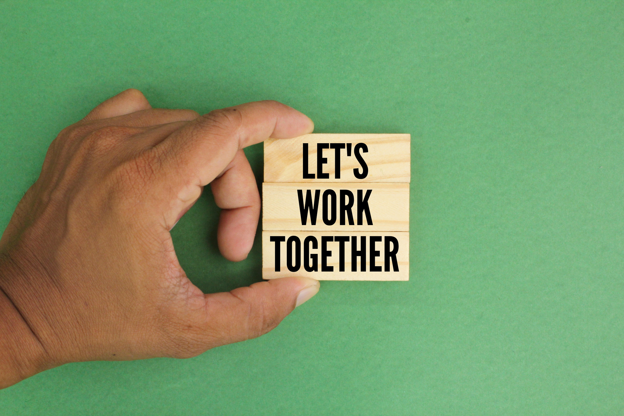 hand holding a stick with the words Let’s work together. the concept of working together. teamwork concept