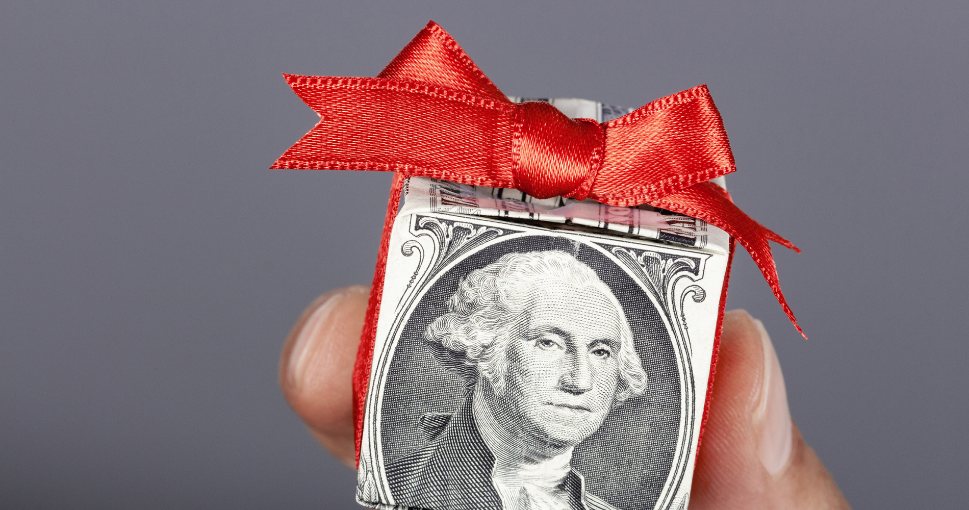 Dollar bill folded and wrapped with a red ribbon. Dollar bill folded and wrapped with a red ribbon.