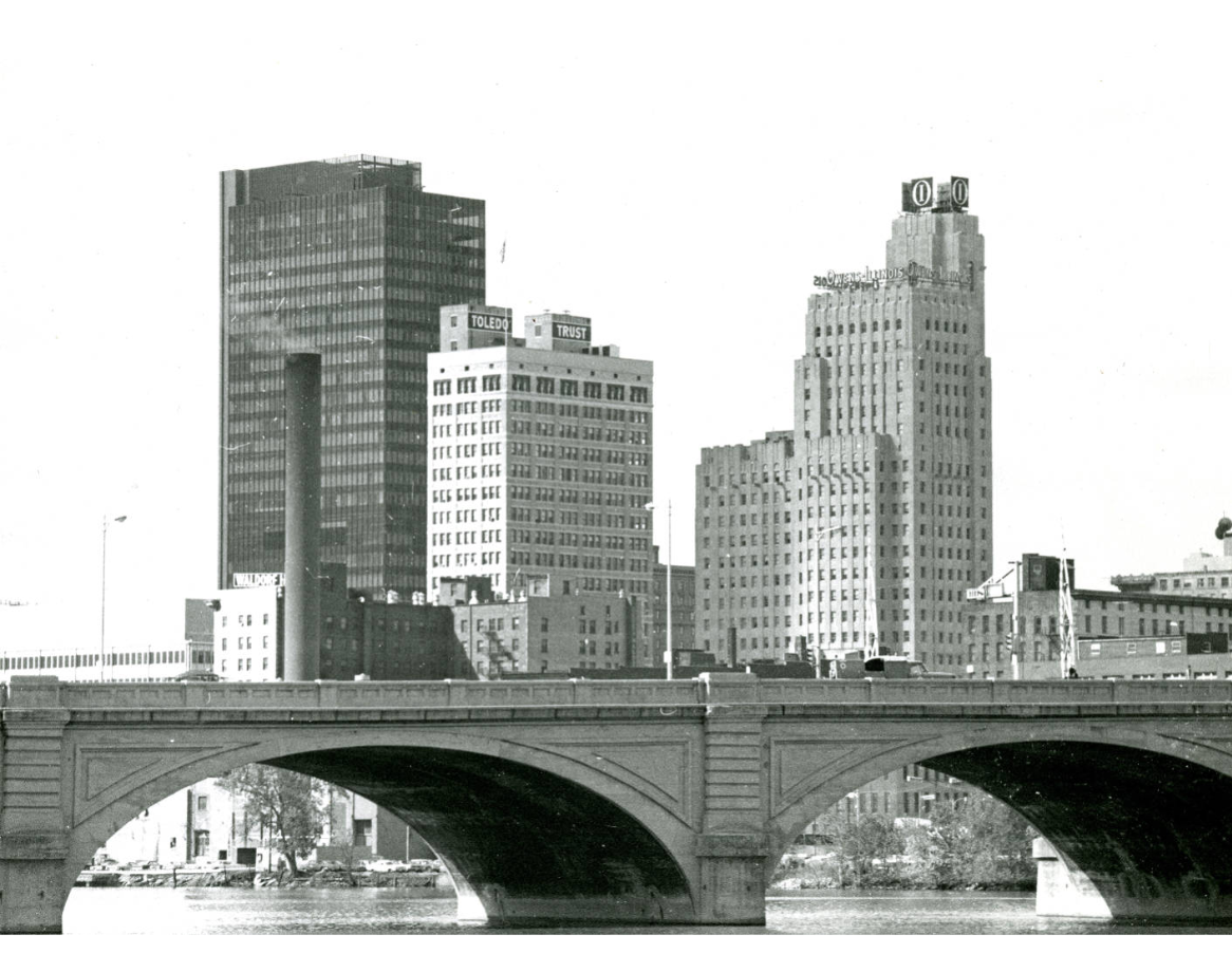 A black and white photograph of the downtown Toledo Maumee River skyline as seen in front of the Cherry Street Bridge, now named MLK Jr. Memorial Bridge. A black and white photograph of the downtown Toledo Maumee River skyline as seen in front of the Cherry Street Bridge, now named MLK Jr. Memorial Bridge.