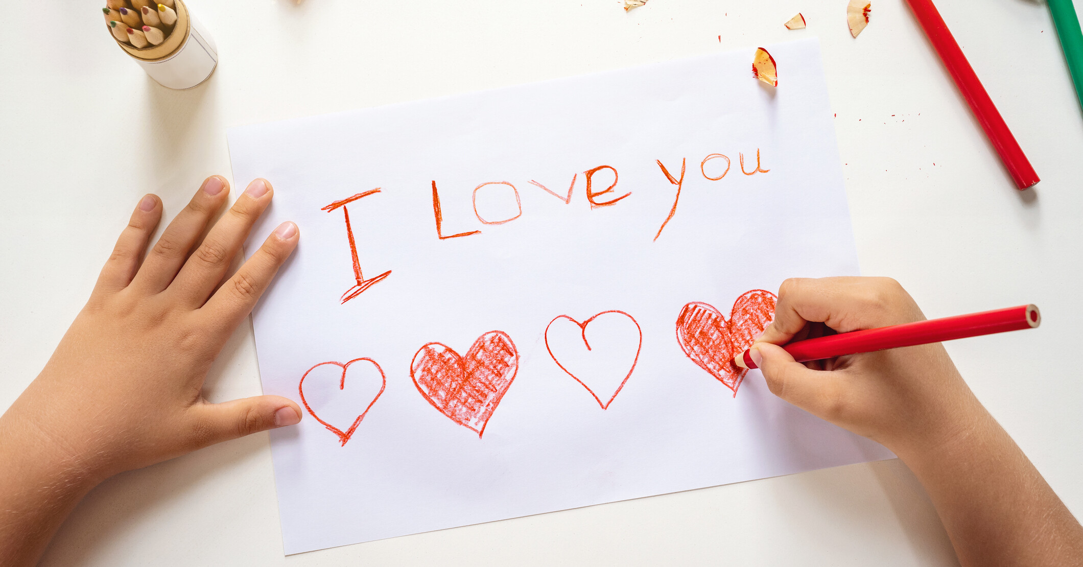Child writing "I love you."