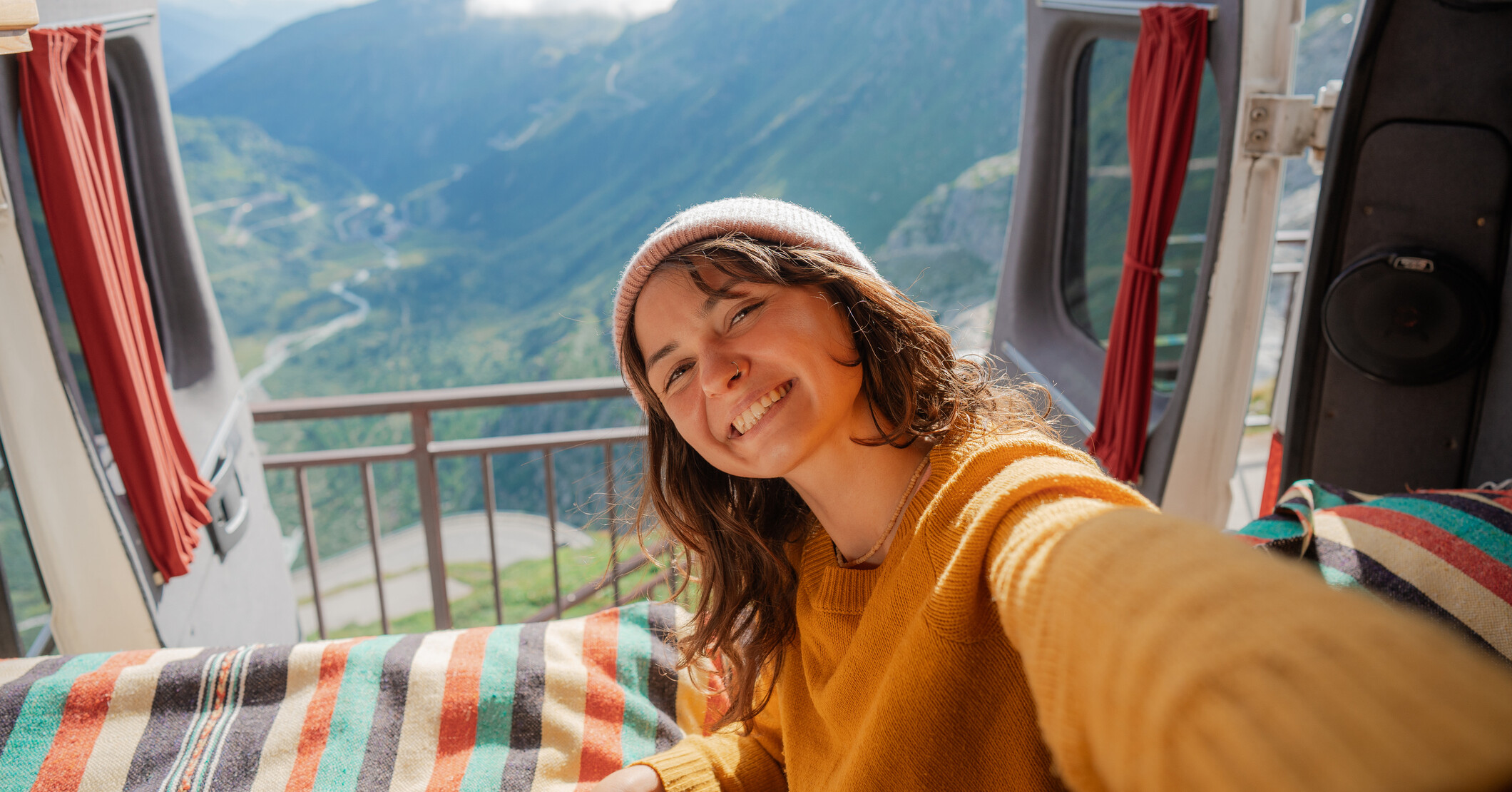 Woman in a camper van overlooking mountains.