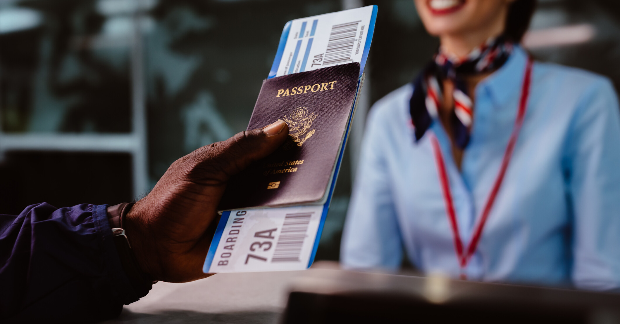 A Black man holding a boarding pass and passport at the airport.