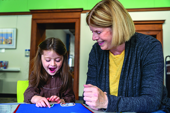 image of a child and adult working on a felt board